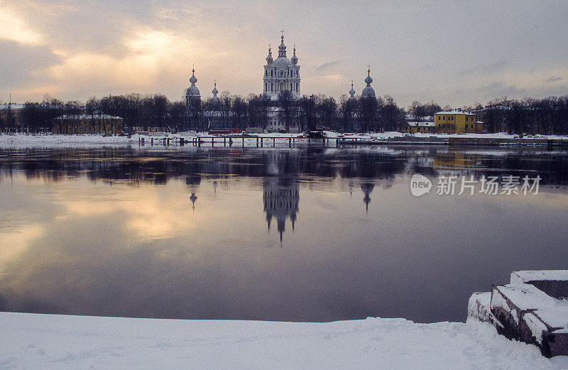 圣彼得斯堡的城市景观与Smol'nyy Sobor教堂和它的倒影在冰冻的涅瓦河。复古冬季捕捉胶片。